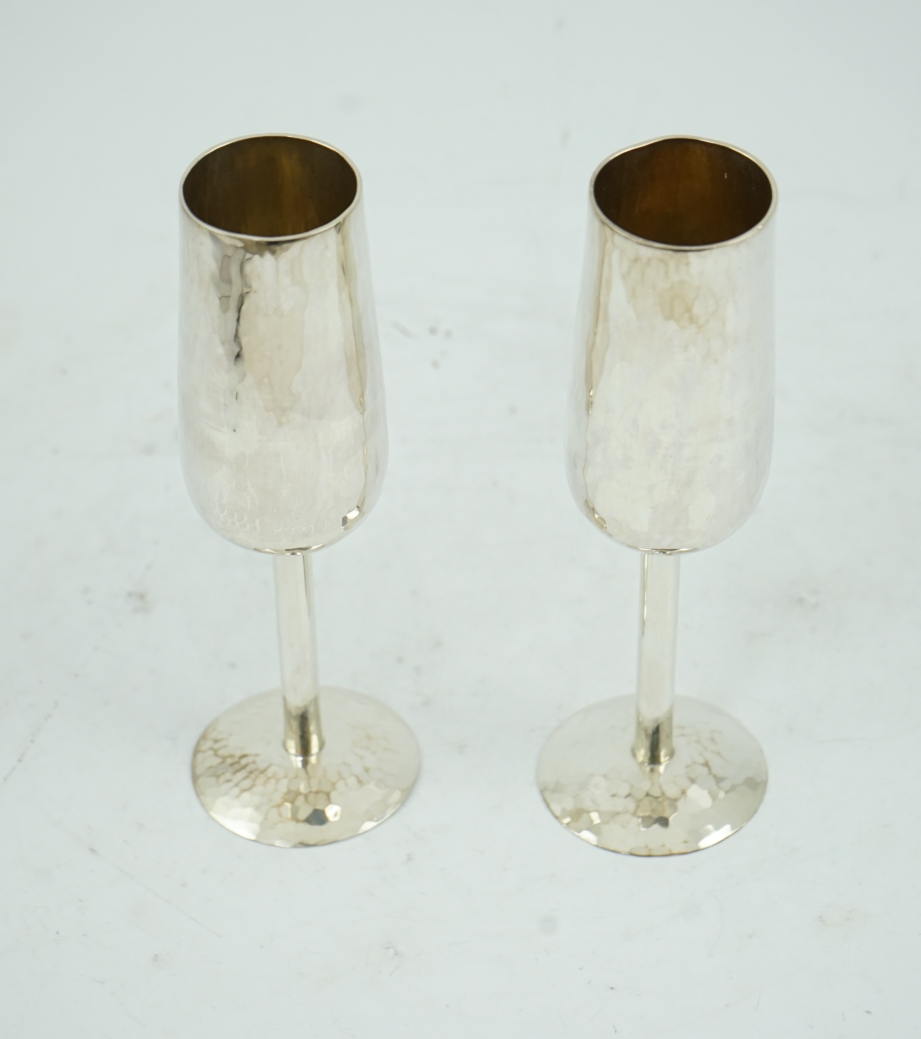 A pair of Elizabeth II planished silver champagne flutes, by Pruden & Smith